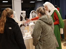 Besucherinnen am Kopfbedeckungsdisplay Besucherinnen am Kopfbedeckungsdisplay